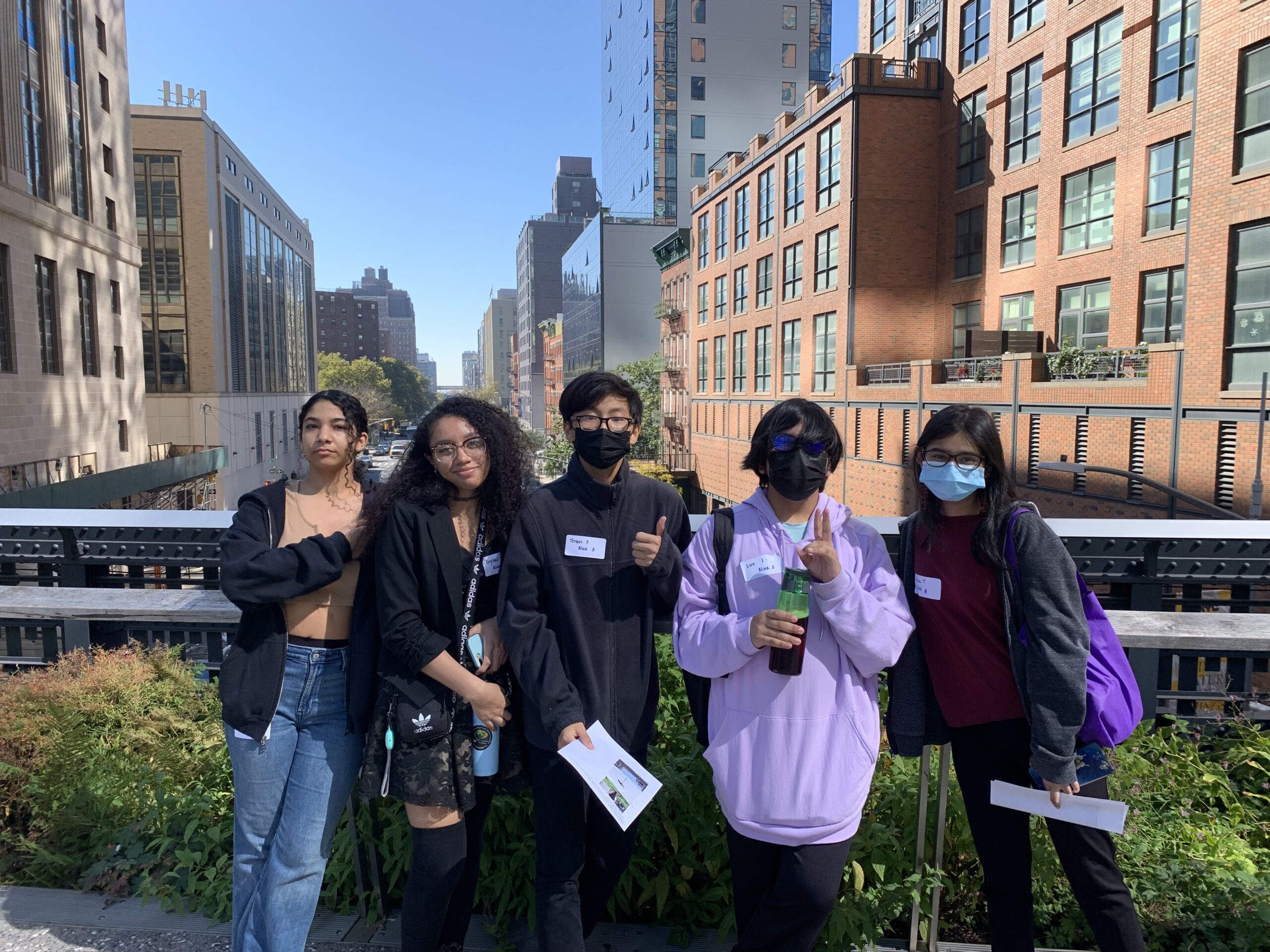 Students posing in front of an elevated view of Manhattan buildings