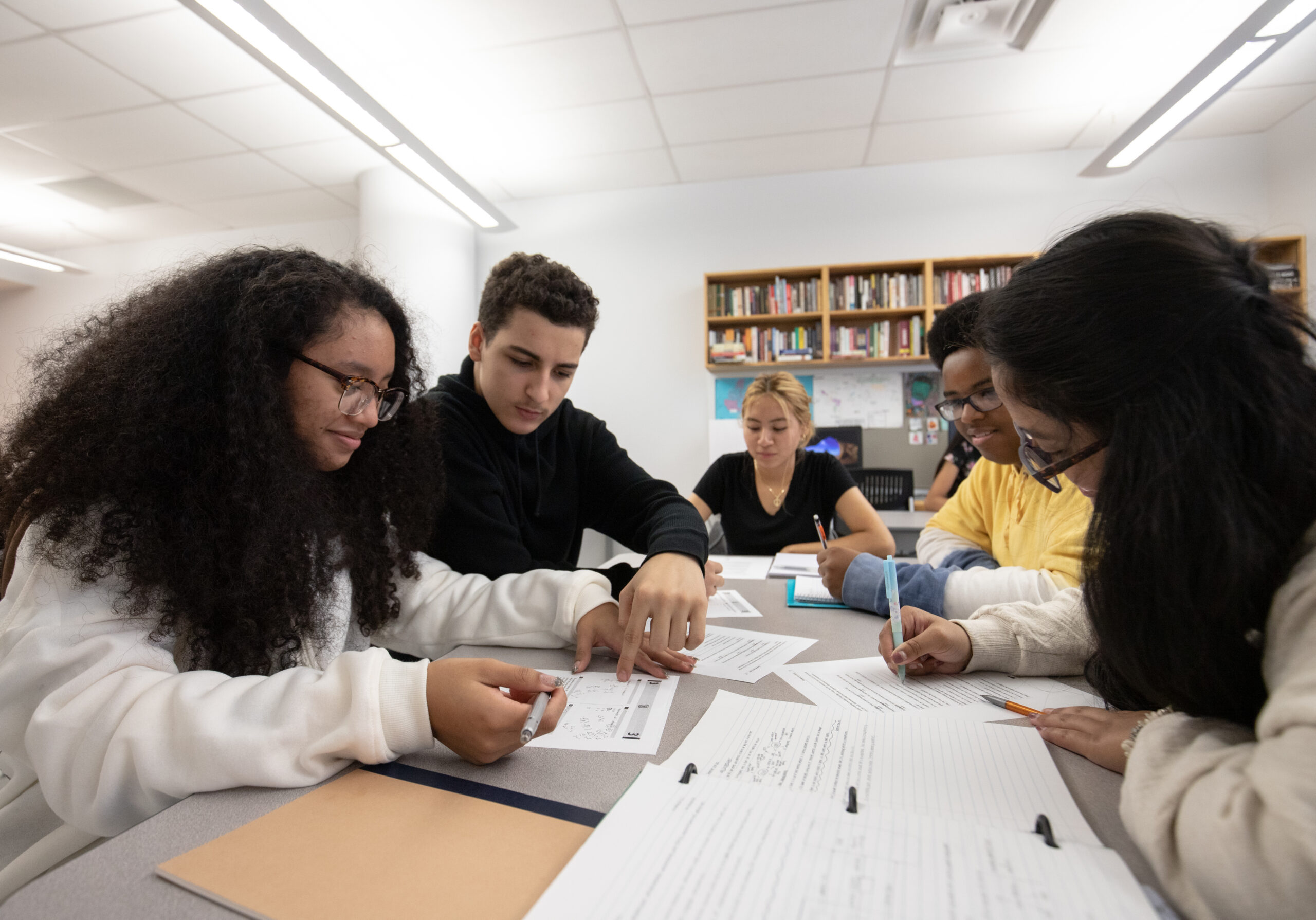 A group of students studying with worksheets